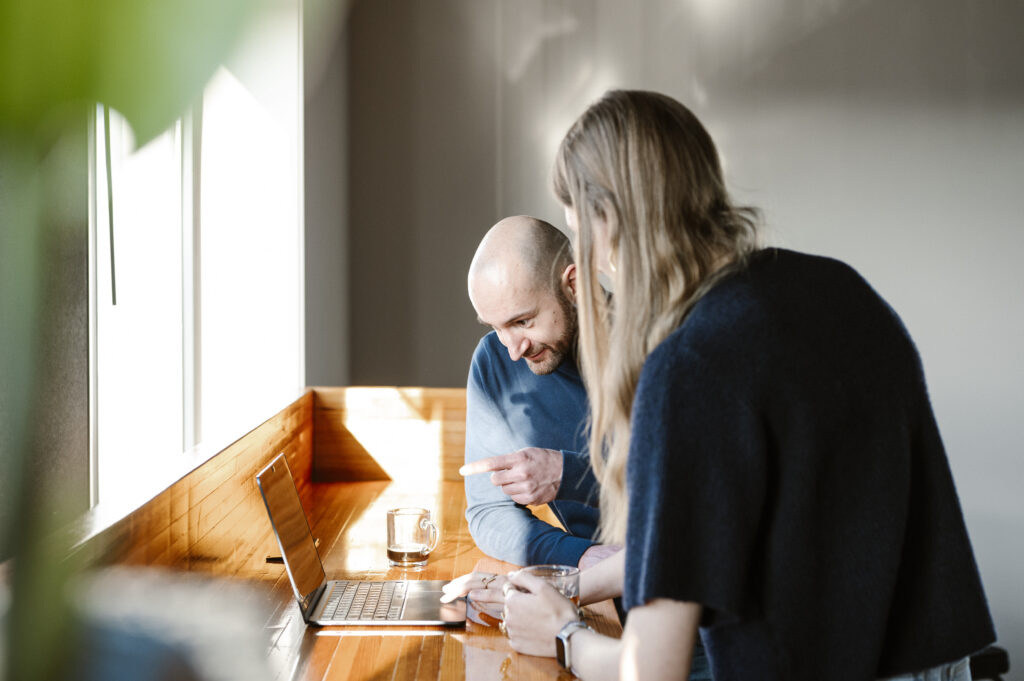 Vrouw en man bekijken samen iets op een laptop